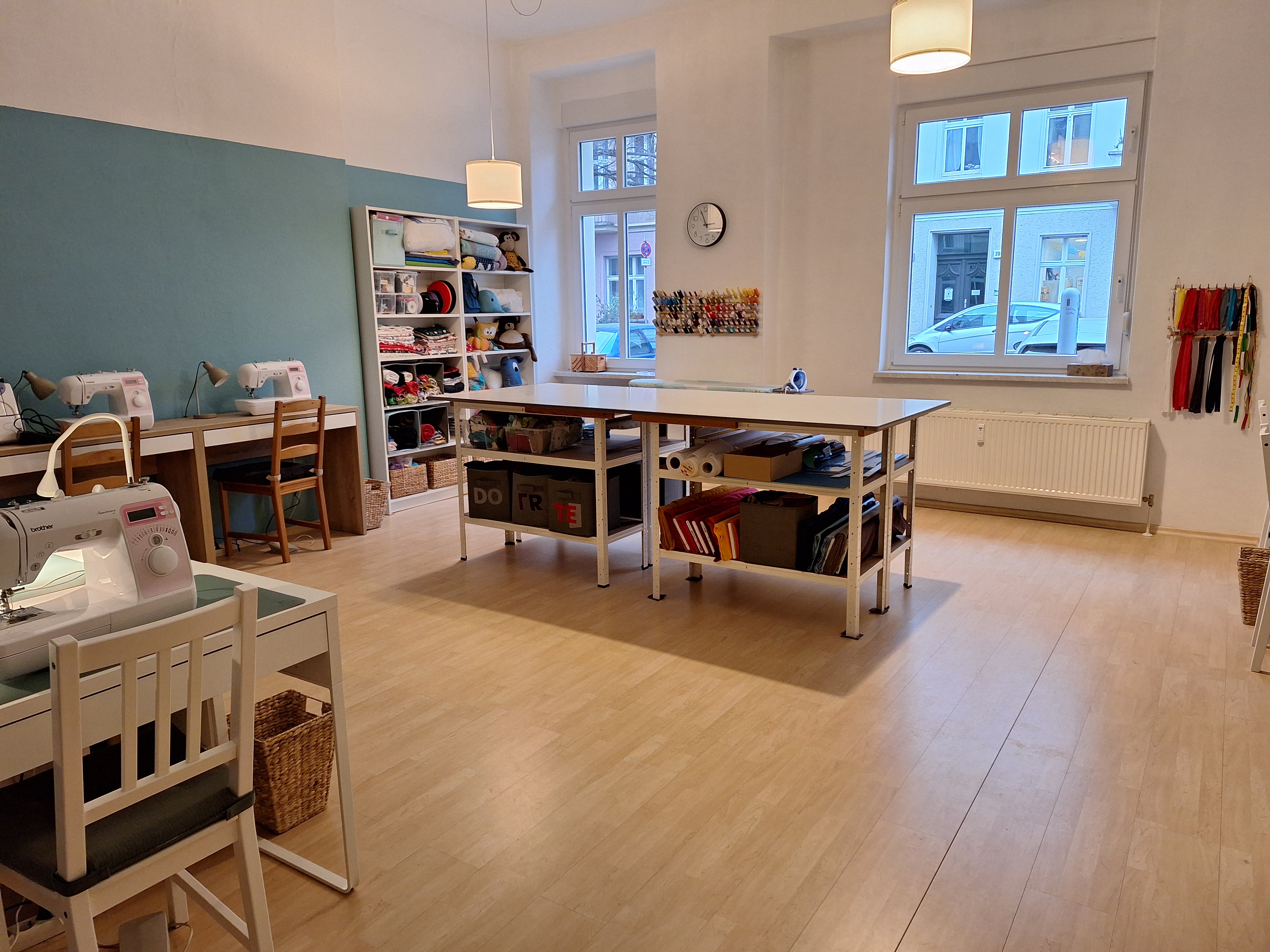Sewing room with tables and shelves, bright interior.