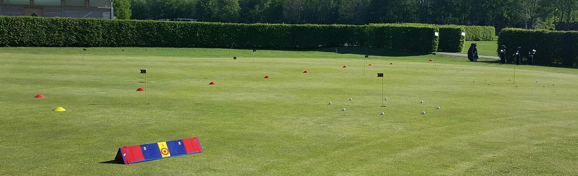Golf training area with flags and cones.