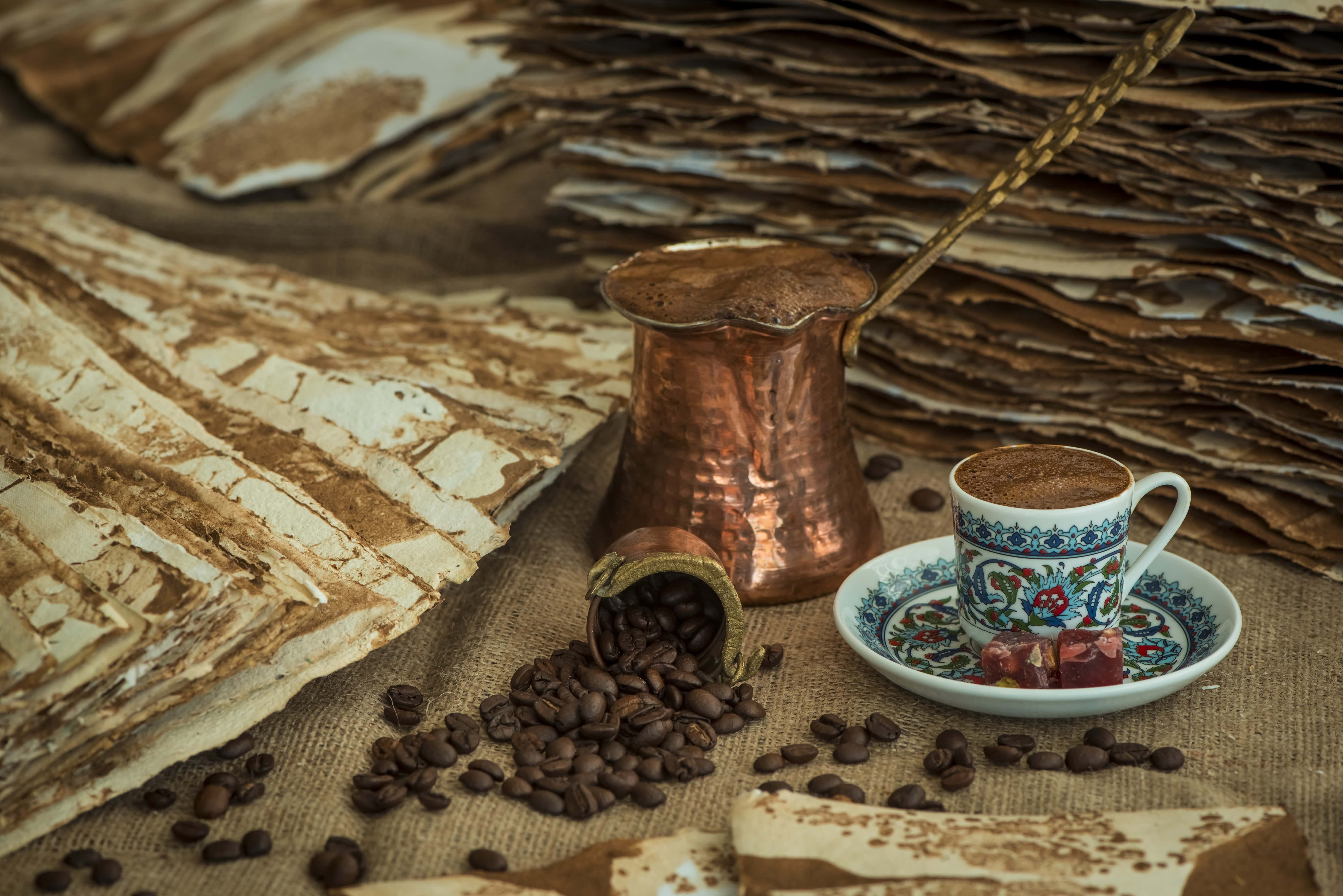 Coffee cup and pot with beans, rustic background.