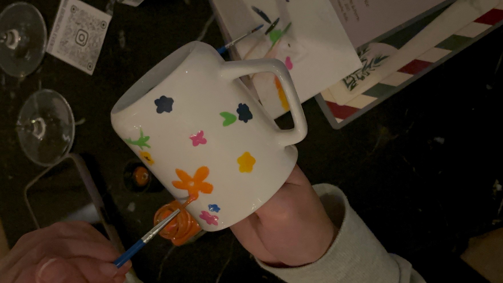 Hand bemalt weiße Tasse mit bunten Blumen.