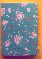 Buch mit Blumenmuster auf Holztisch.