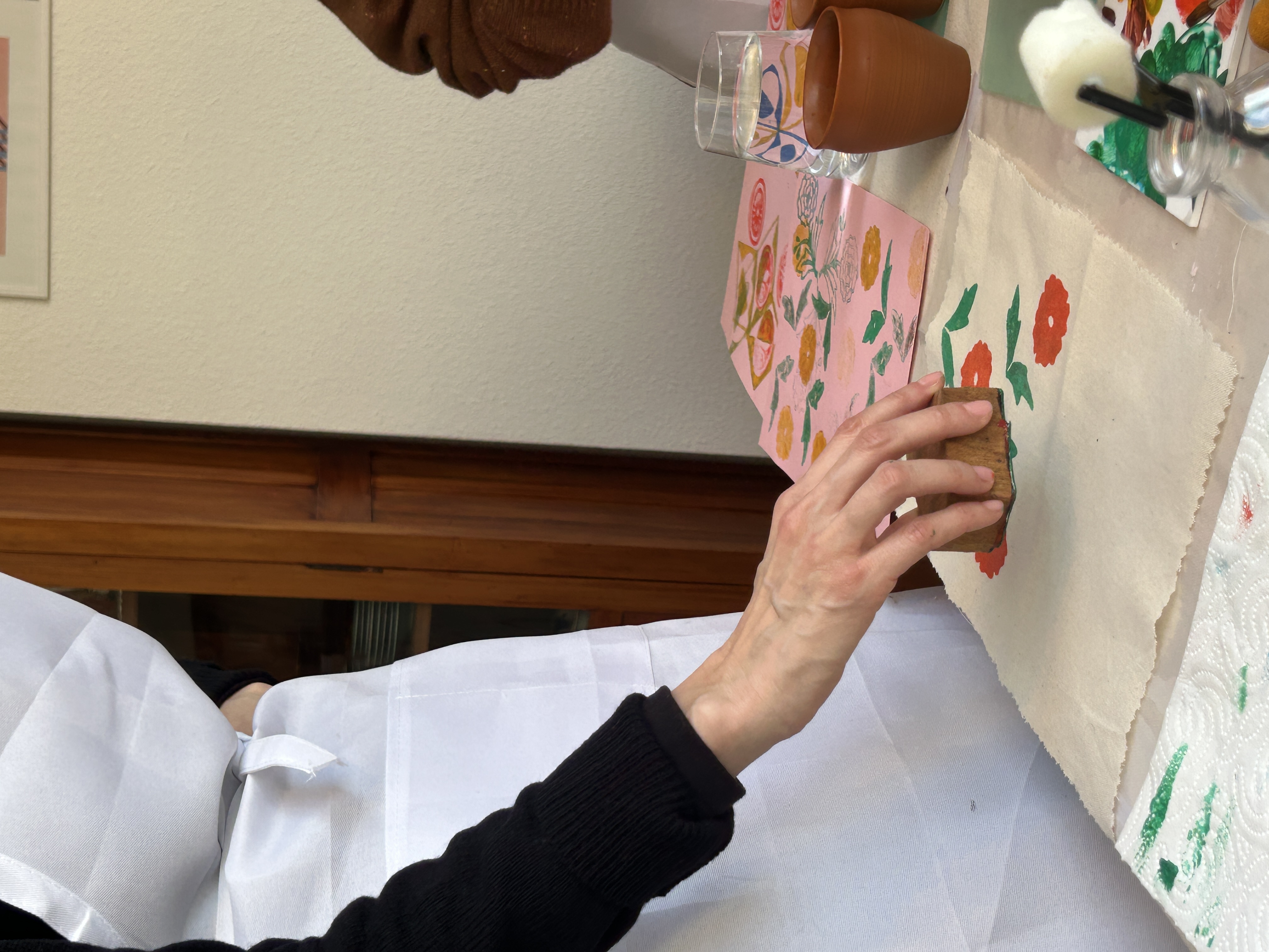 Hand benutzt Stempel auf Stoff mit Blumenmuster.