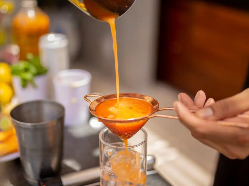 Liquid strained through a fine sieve into glass.