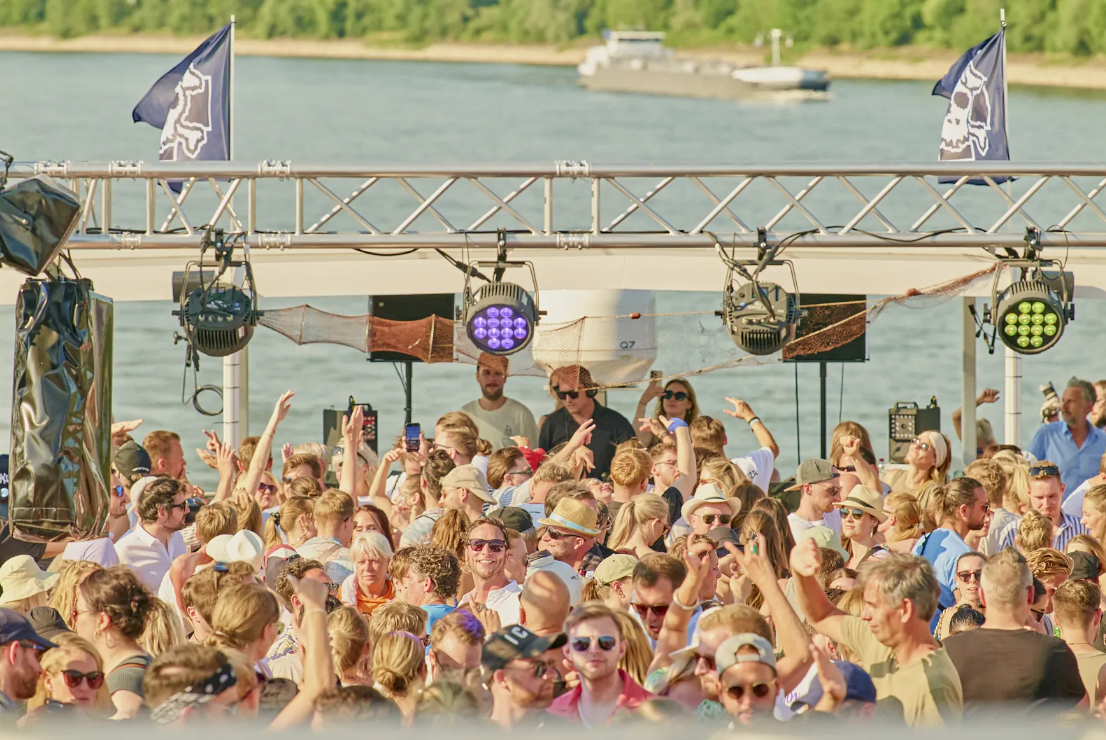 Crowd dancing on a boat with DJ.