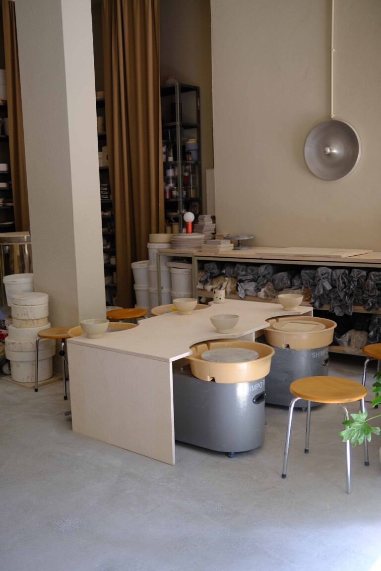 Pottery studio with wheels and stools.