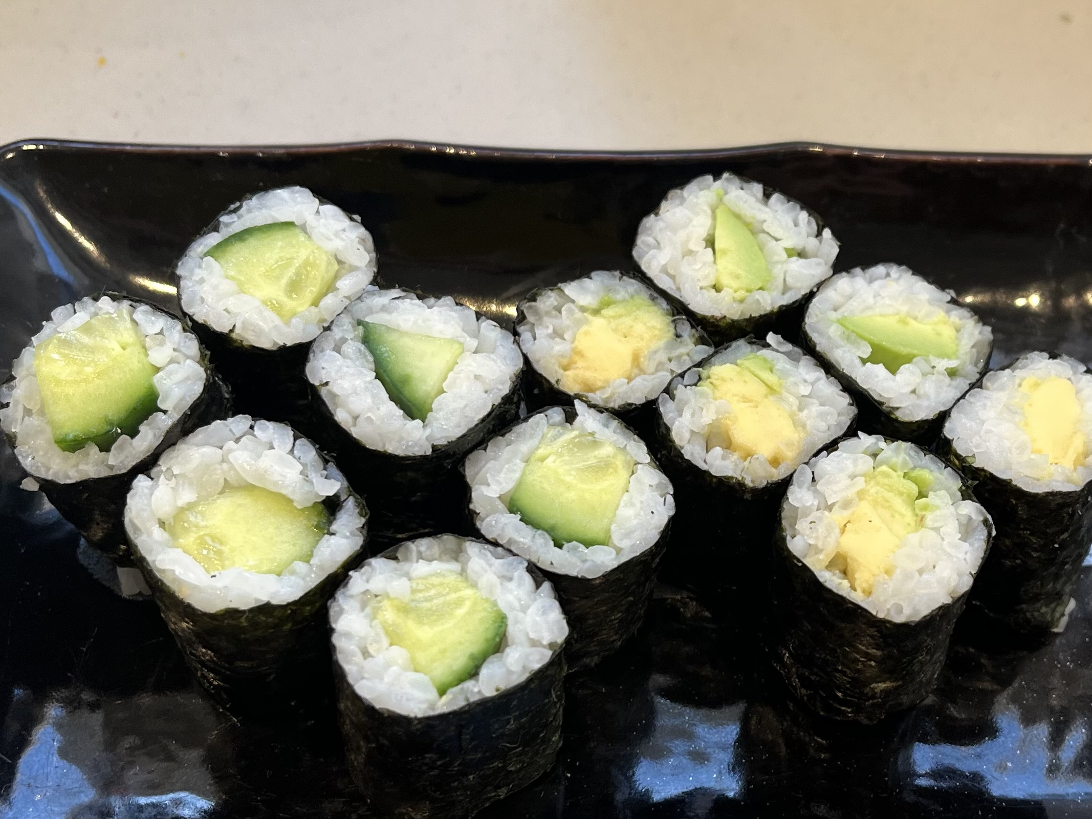Gurken- und Avocado-Sushirollen auf Teller.