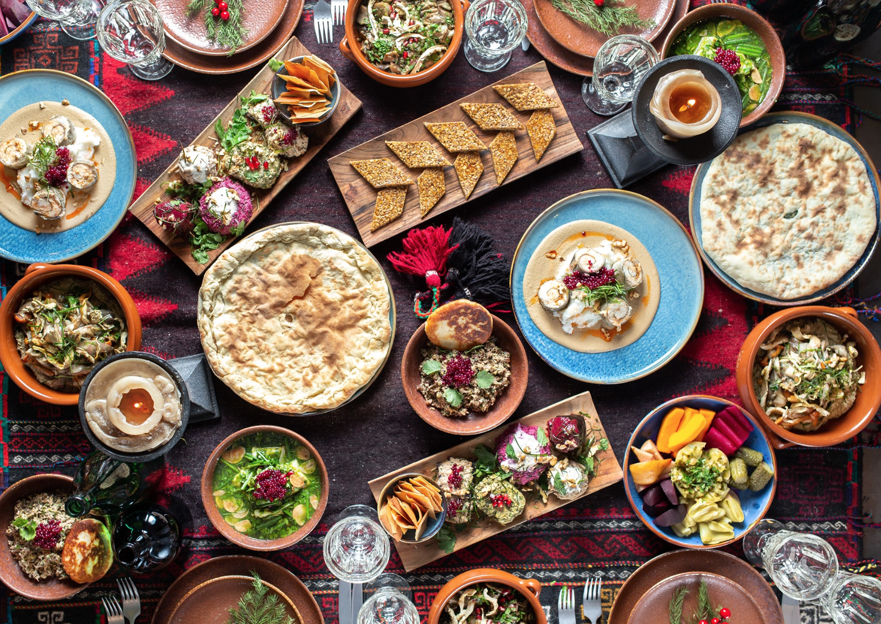 Assorted Middle Eastern dishes on colorful tablecloth.