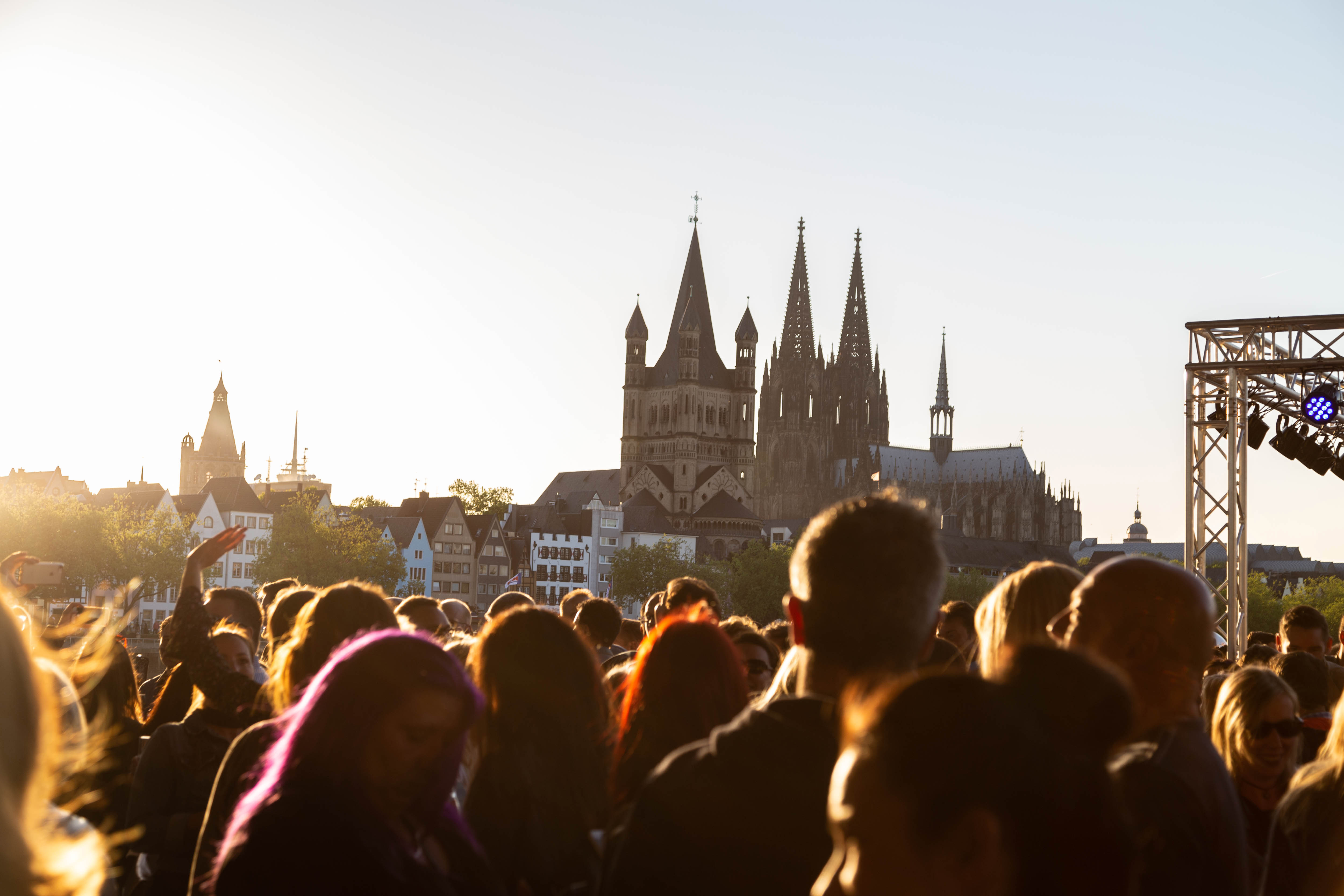 Menschenmenge vor Kölner Dom bei Sonnenuntergang.