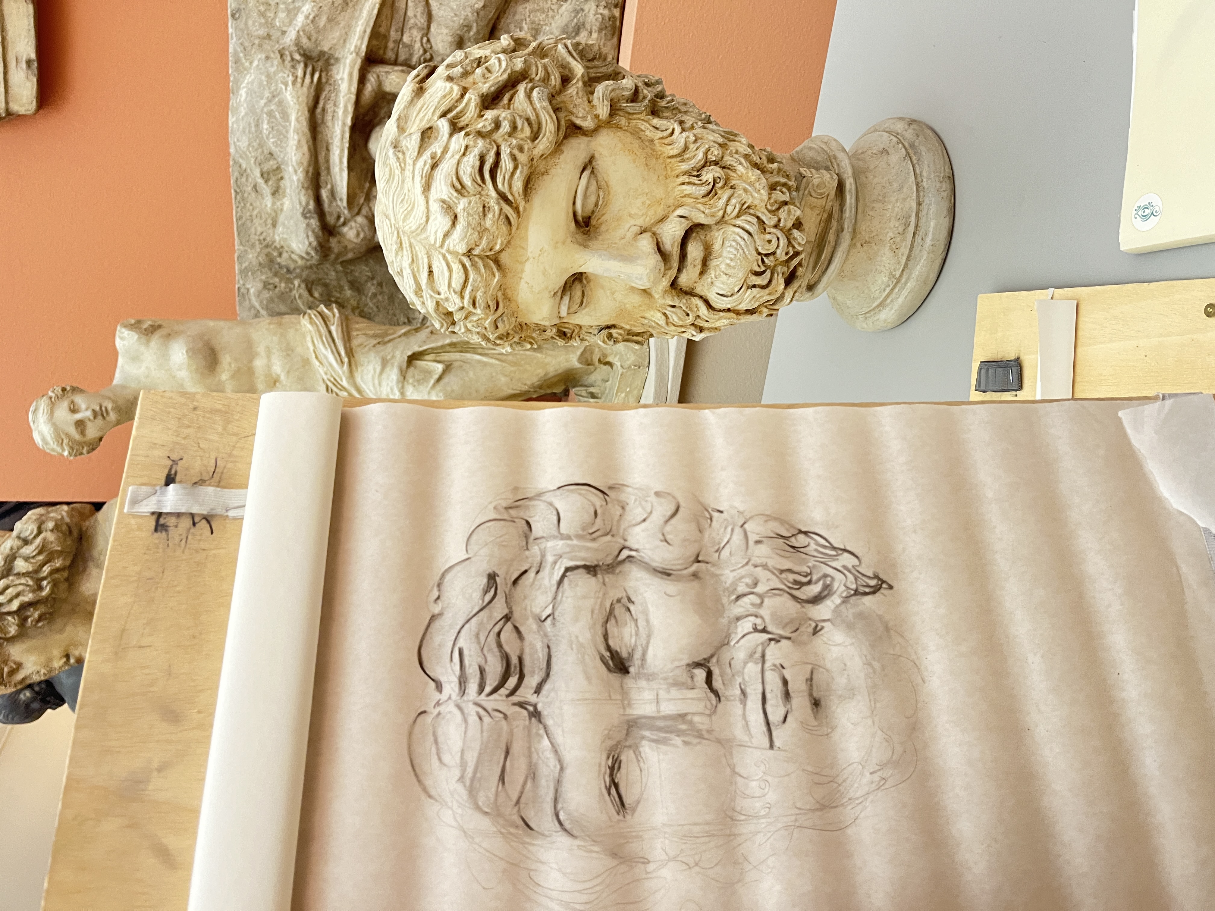 Skizze und Skulptur eines bärtigen Männerkopfs im Museum.