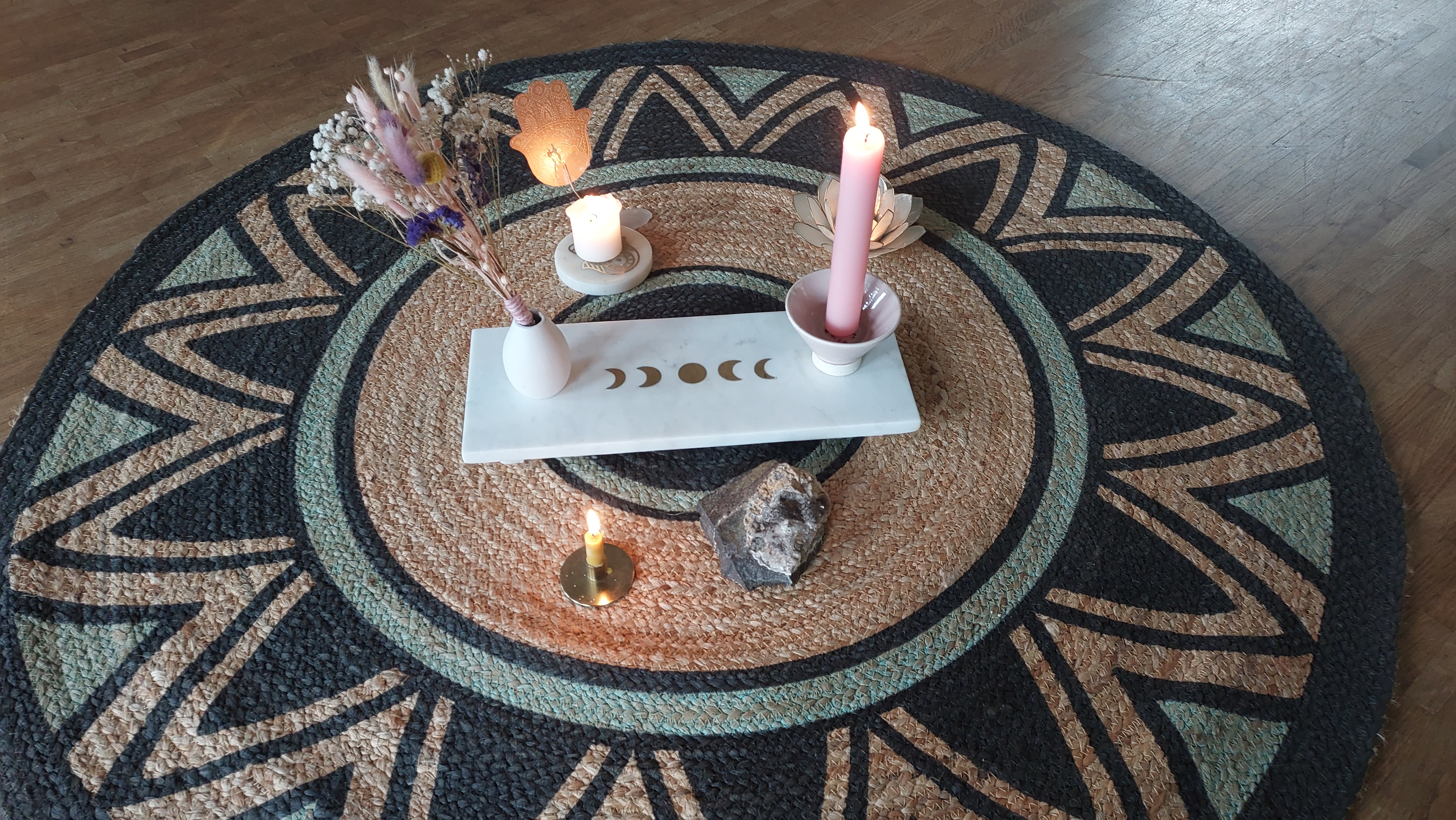 Dekorativer Altar mit Kerzen auf gemustertem Teppich.