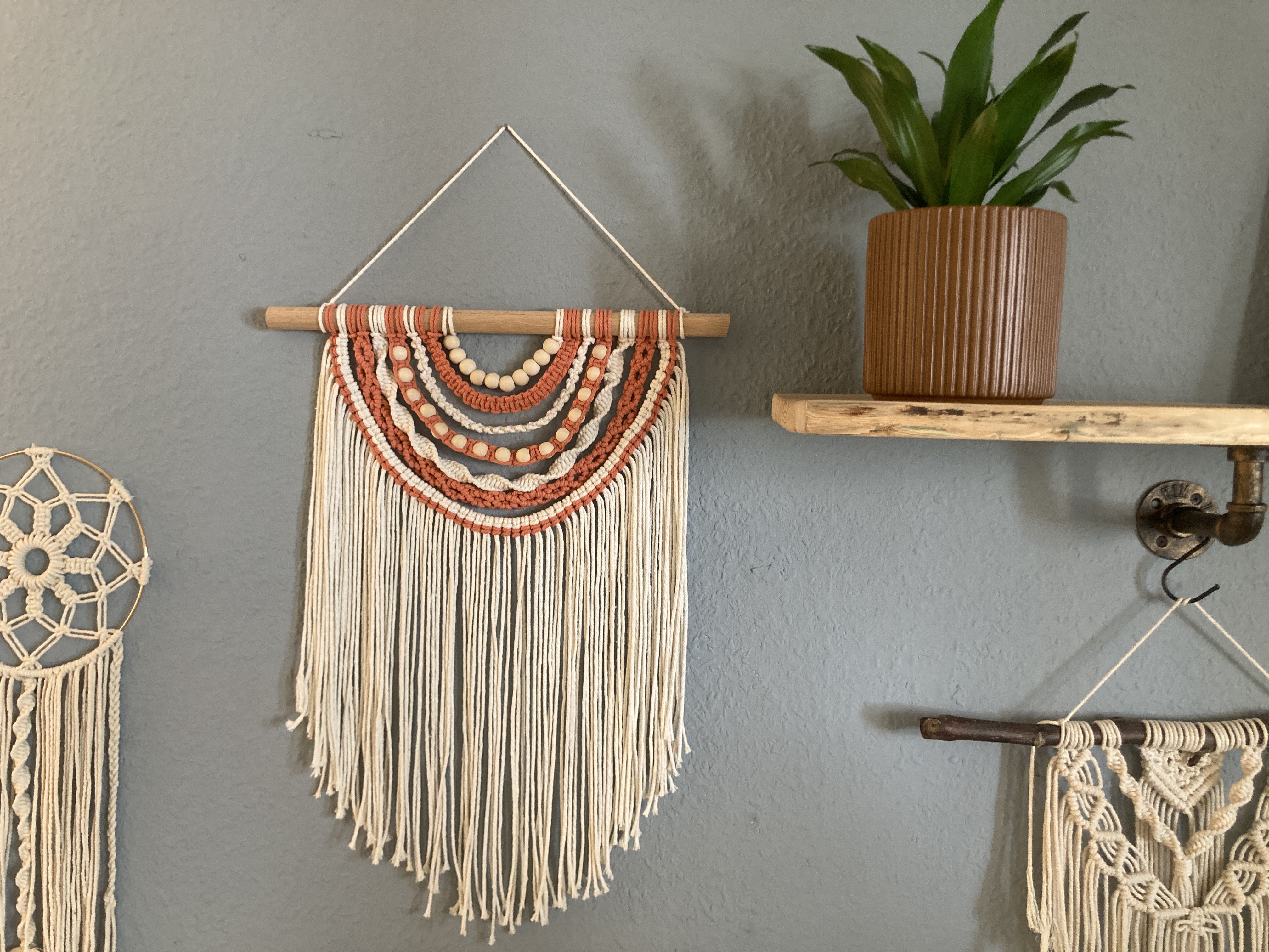 Handgefertigtes Makramee-Wandbehang an blauer Wand.