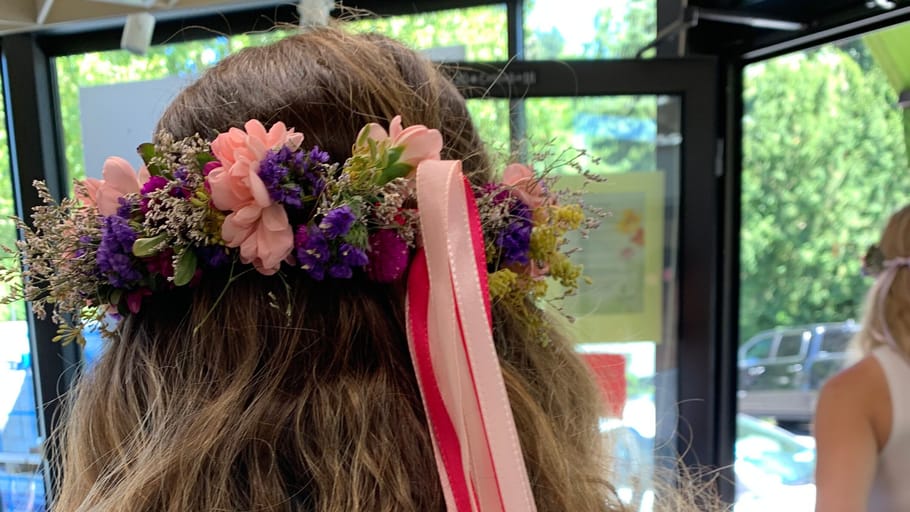 Frau mit Blumenkronen in einem Raum.