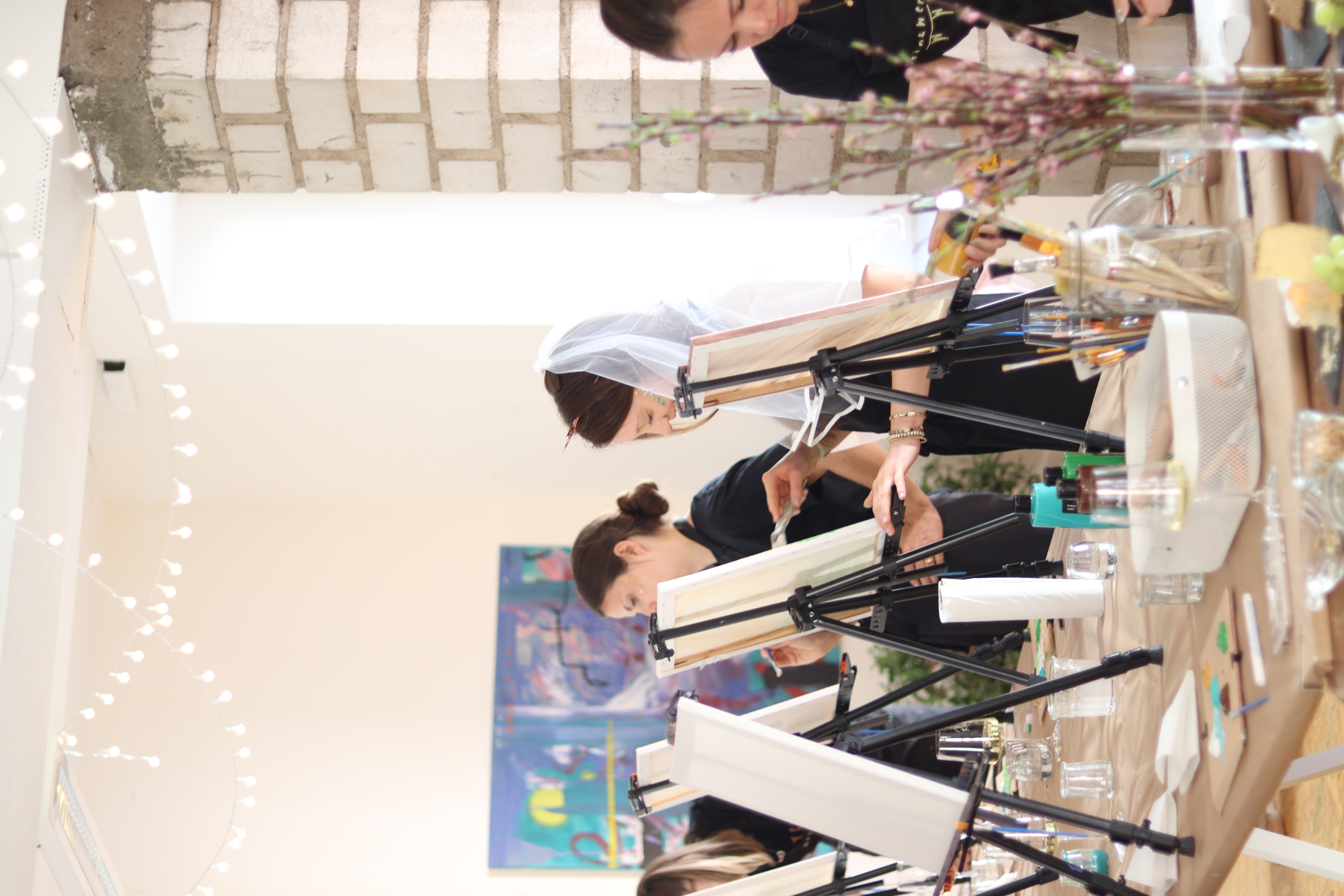 Women painting on canvases in a class.