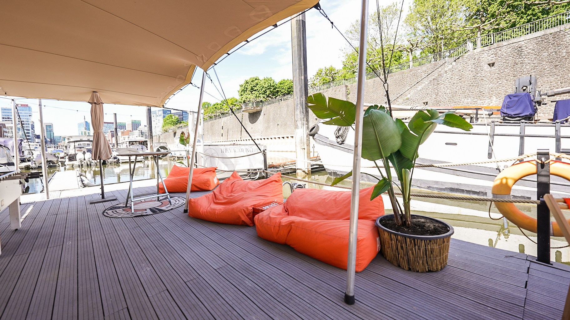 Deck mit orangefarbenen Sitzsäcken und Pflanze.