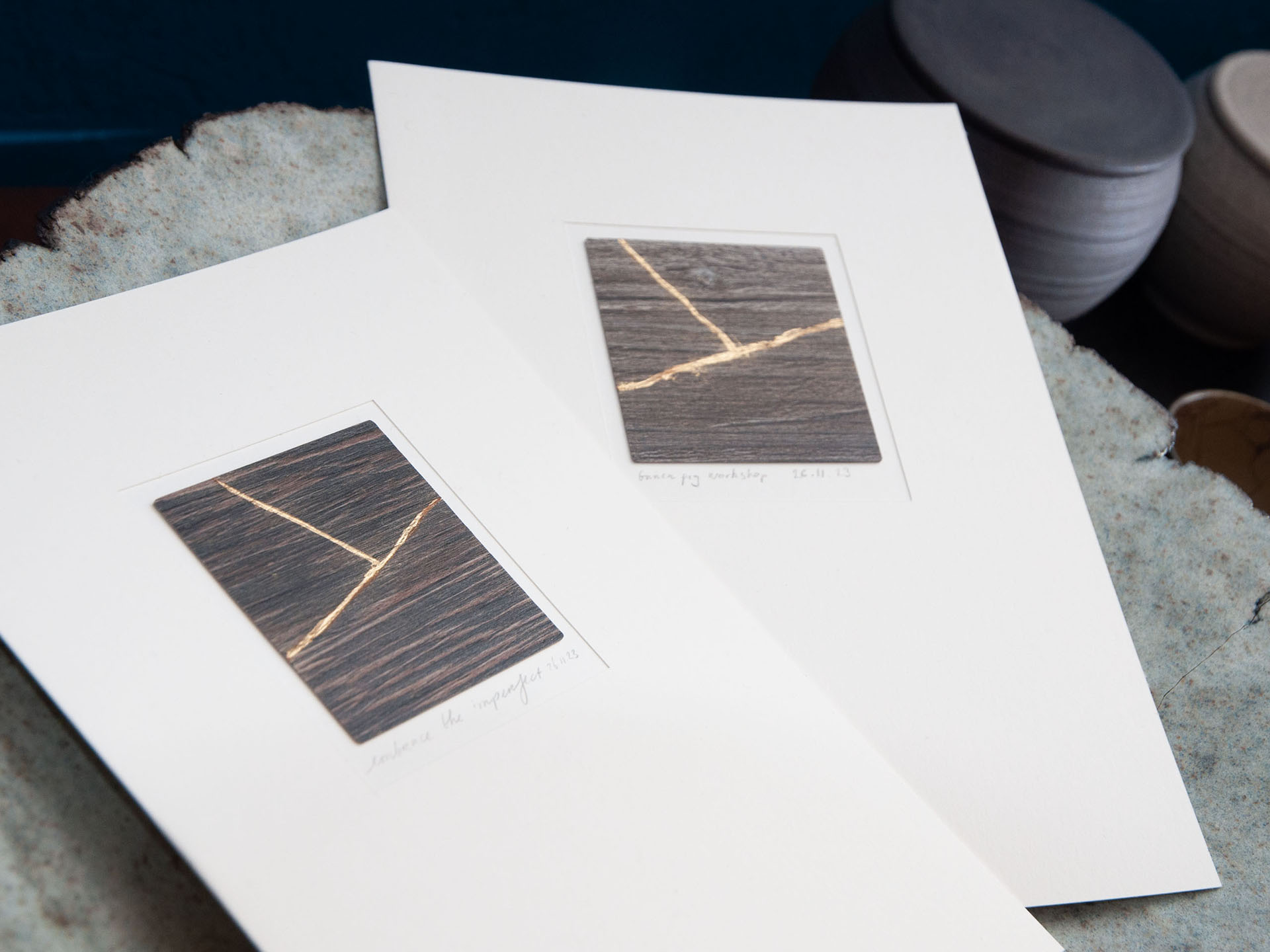 Two abstract art prints on a surface.