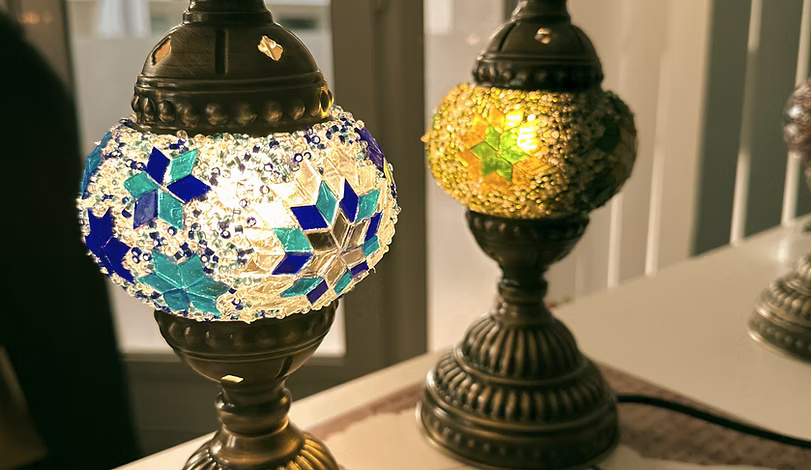 Colorful mosaic lamps lit on a table.