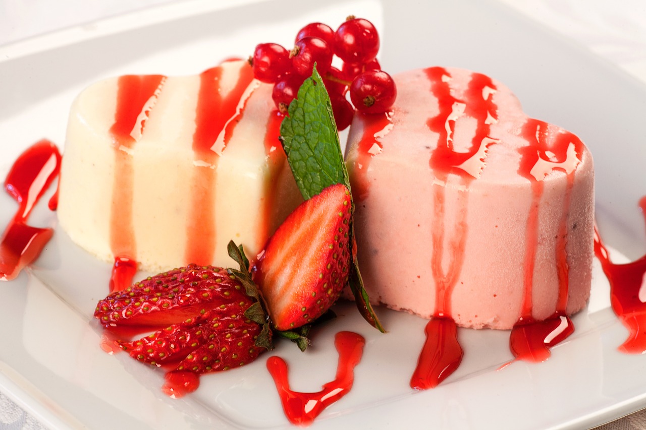 Two heart-shaped desserts with berry garnish.