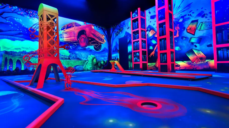 Glowing mini-golf course with vivid murals.