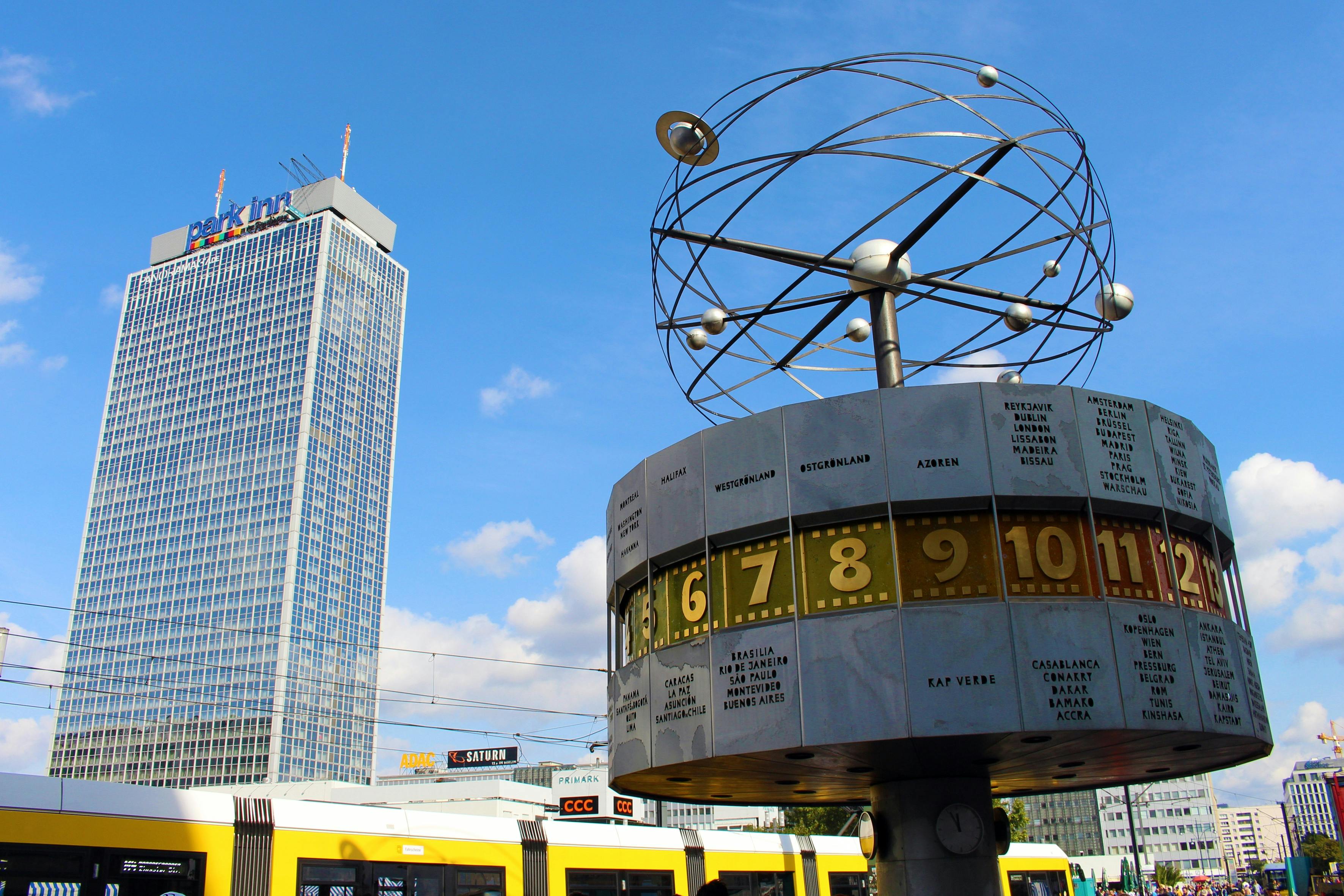 Weltzeituhr auf Stadtplatz mit Wolkenkratzer.
