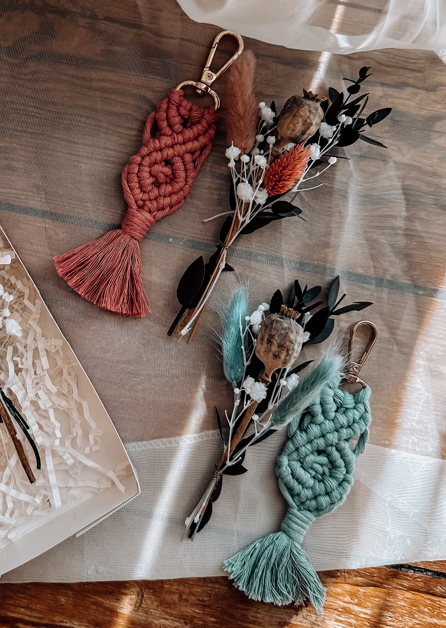 Macrame keychains with dried flowers on table.