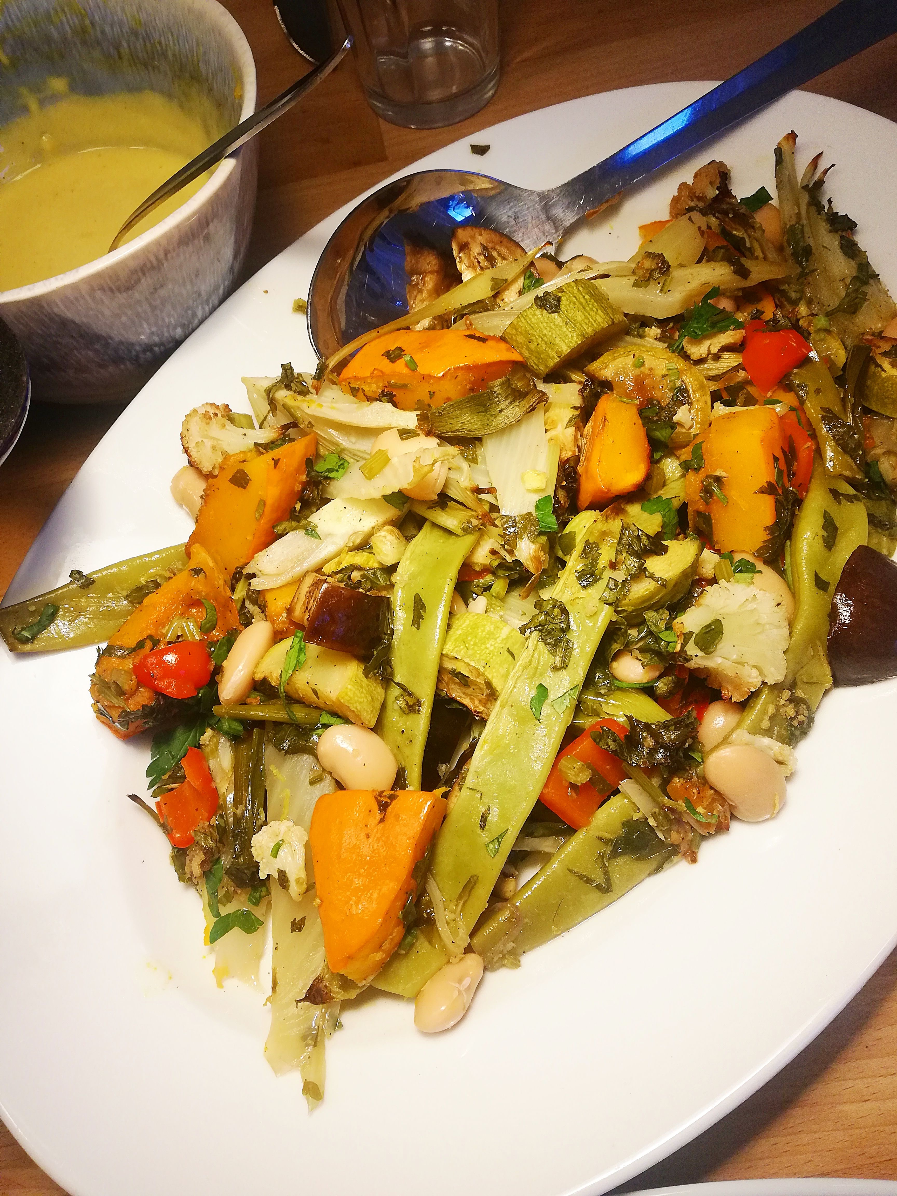 Roasted vegetables with herbs on a plate.