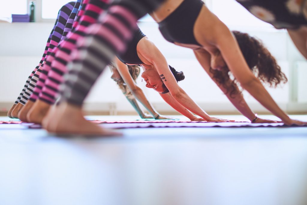 Menschen machen Yoga Herabschauender Hund im Studio.