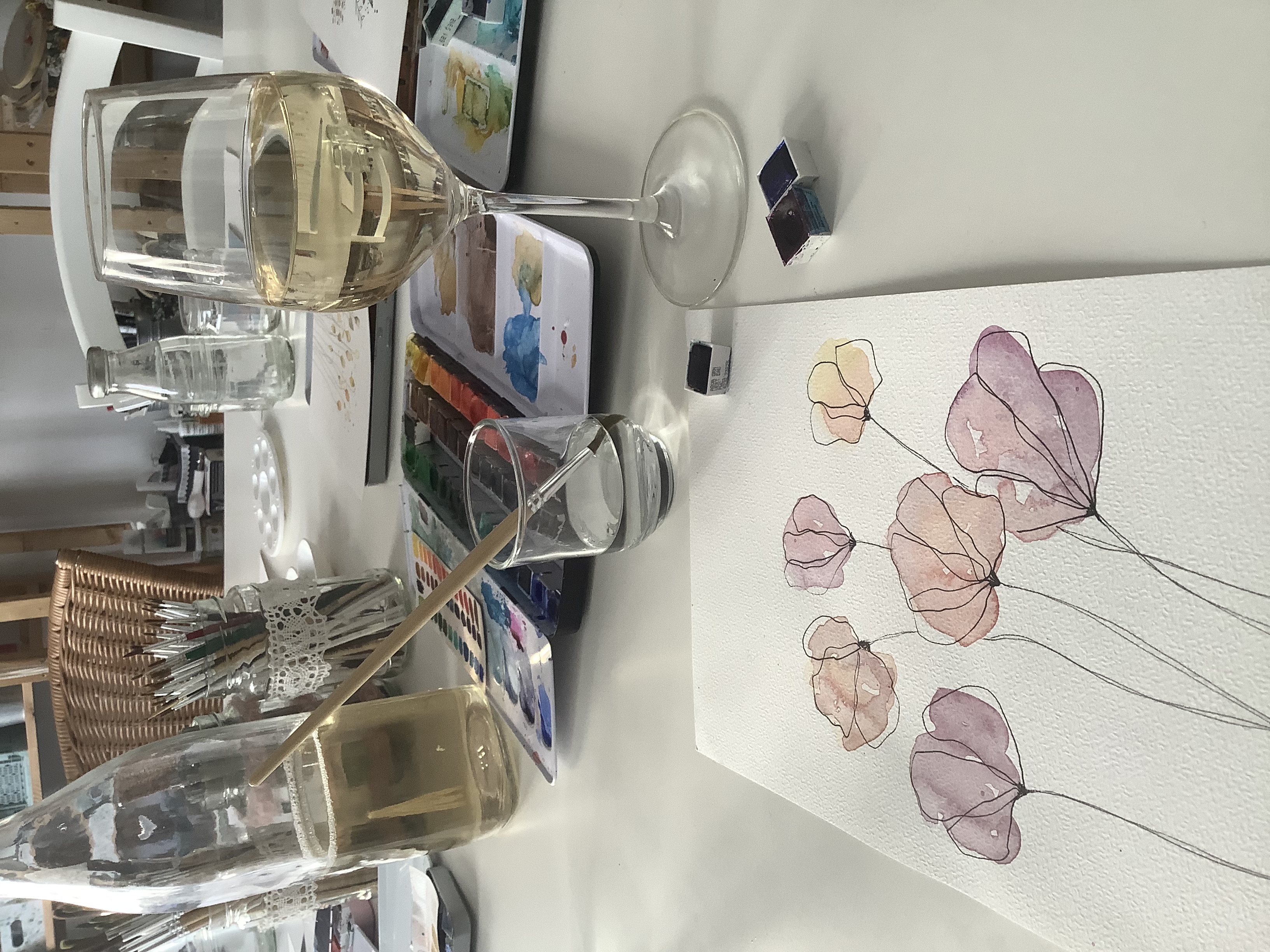Aquarell-Malsetup mit Blumen und Wein.