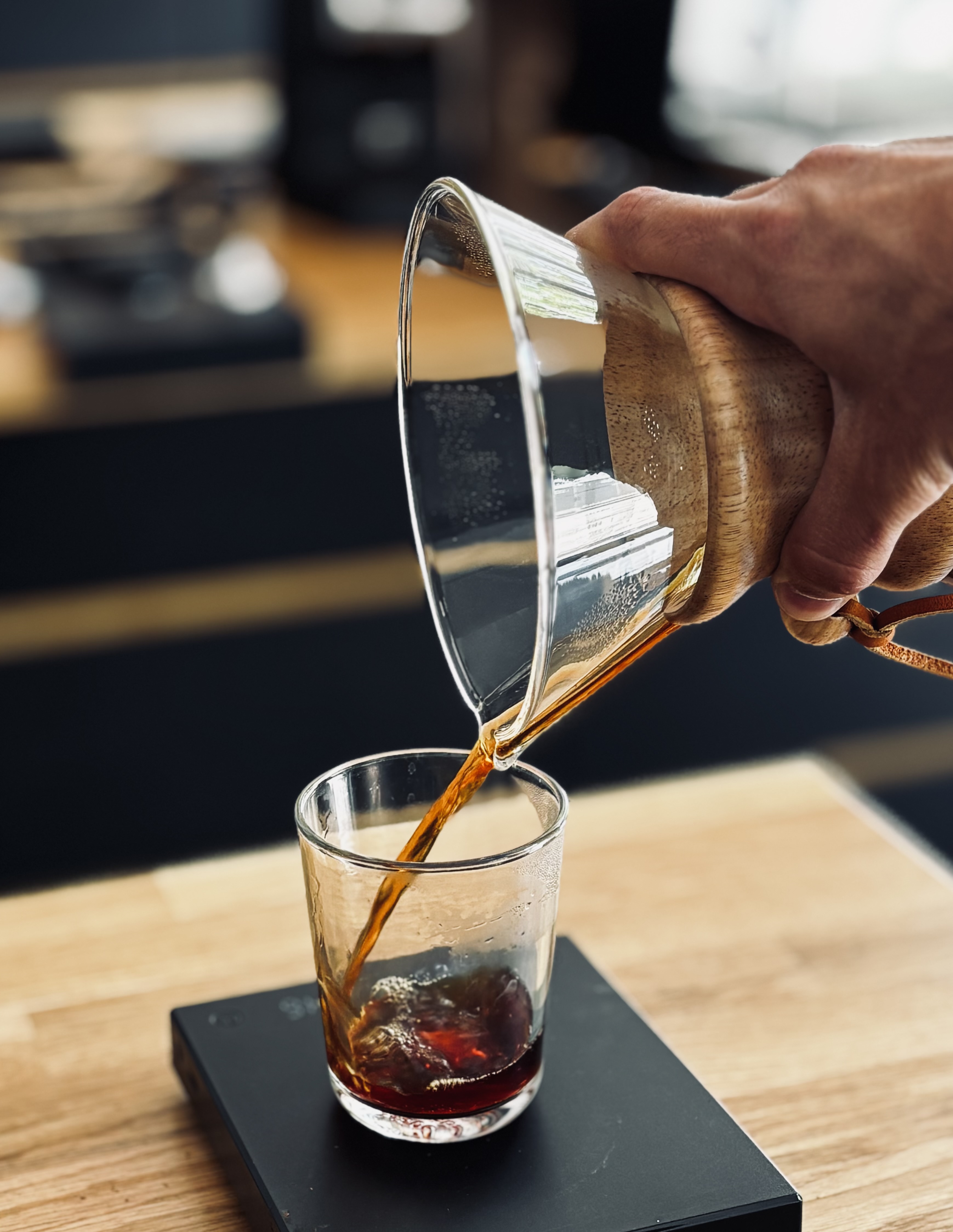 Coffee pouring from carafe into a glass.
