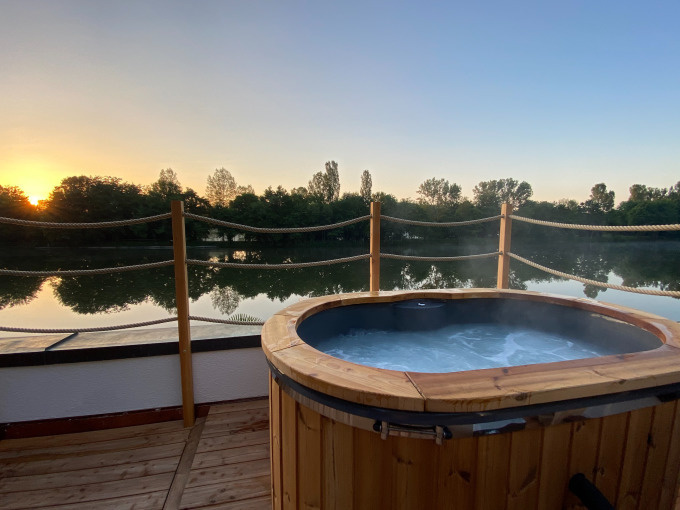Hot tub steaming on a lakefront deck.