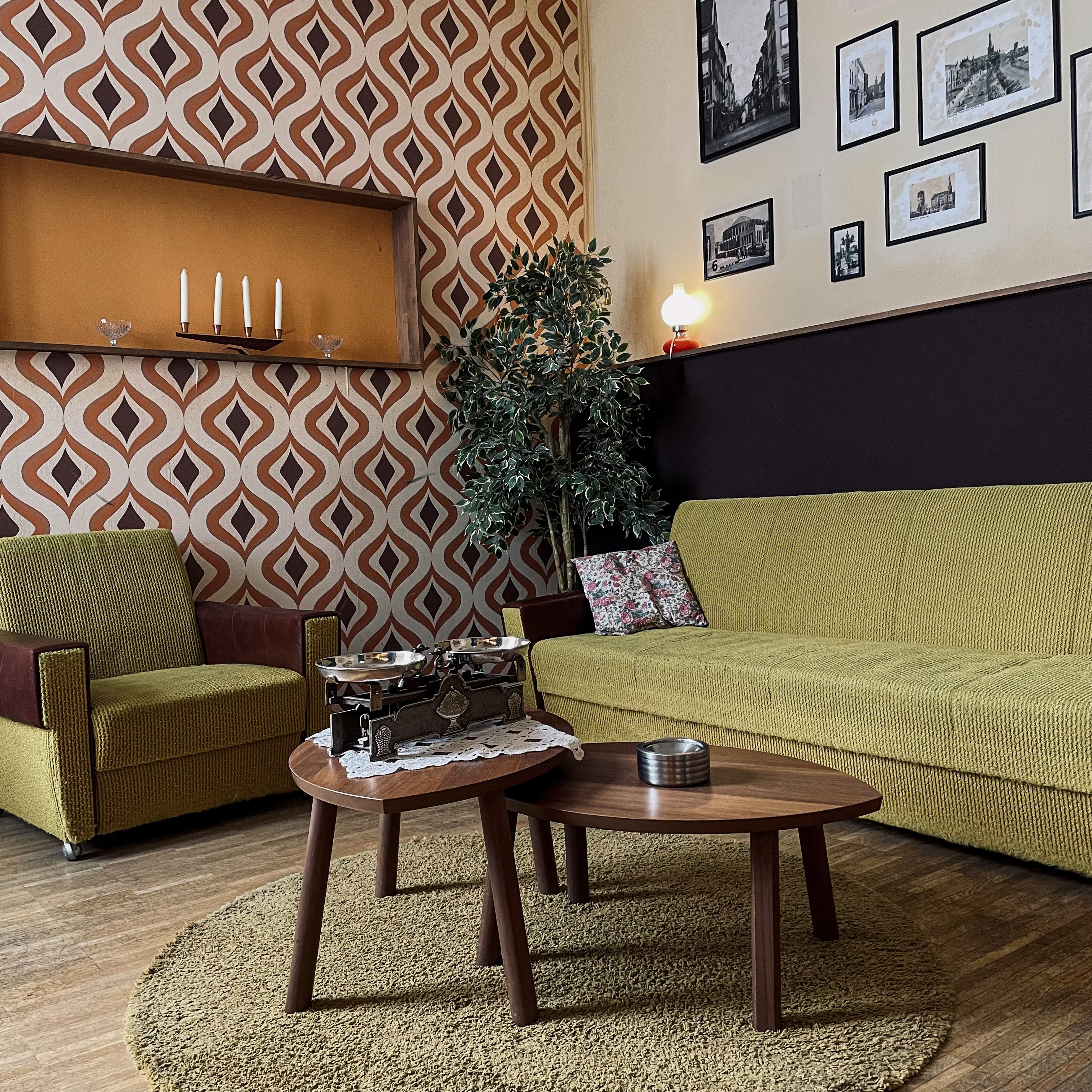 Retro living room with patterned wallpaper, vintage furniture.