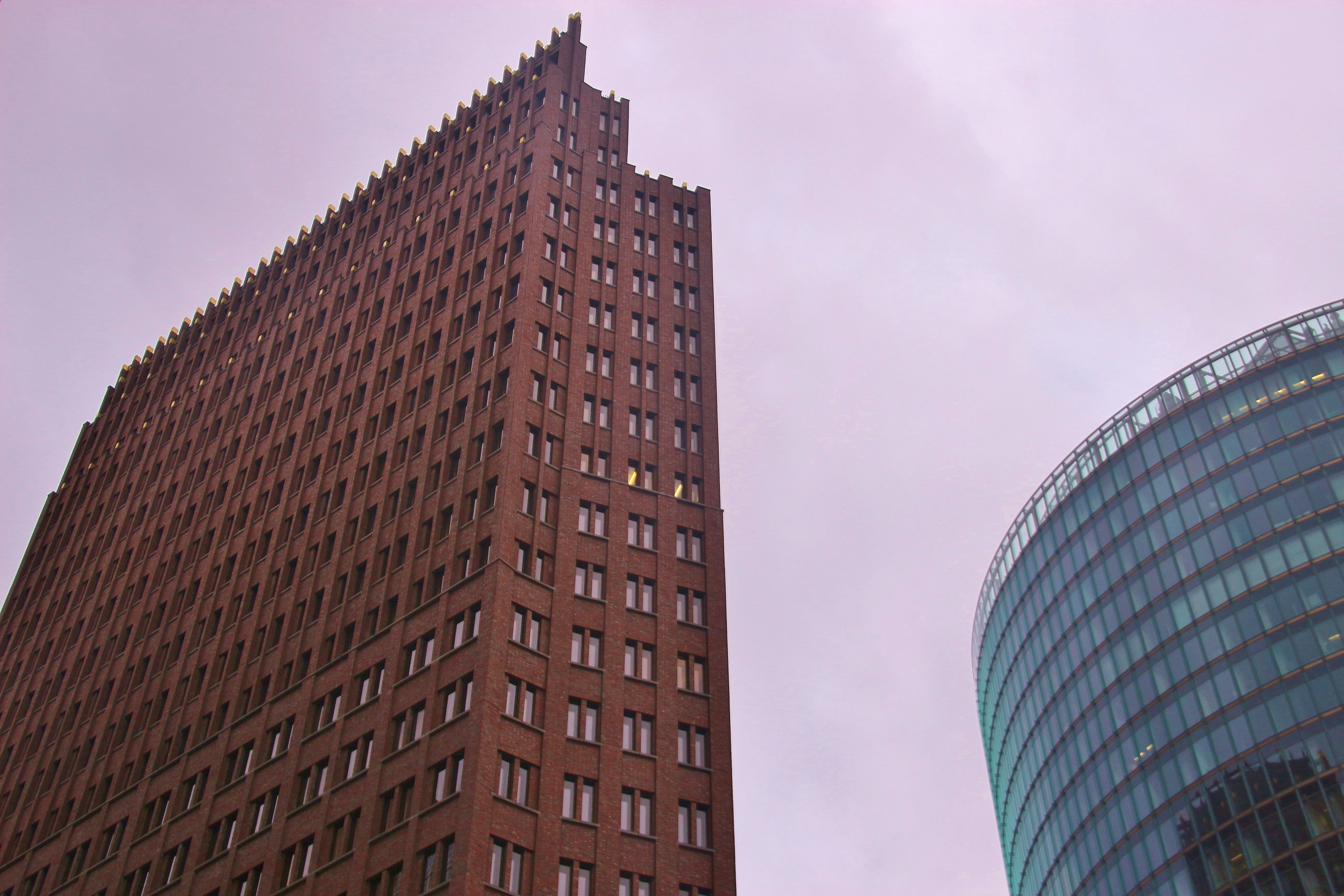 Hohes Backsteingebäude neben Glasstruktur.