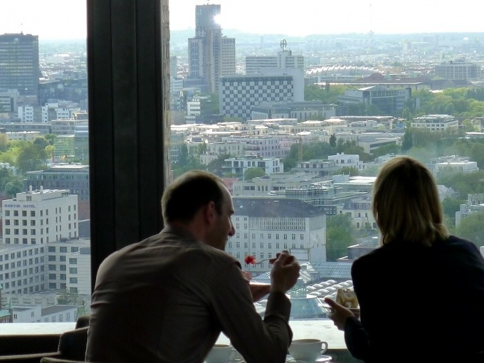 Two people dining overlooking cityscape.
