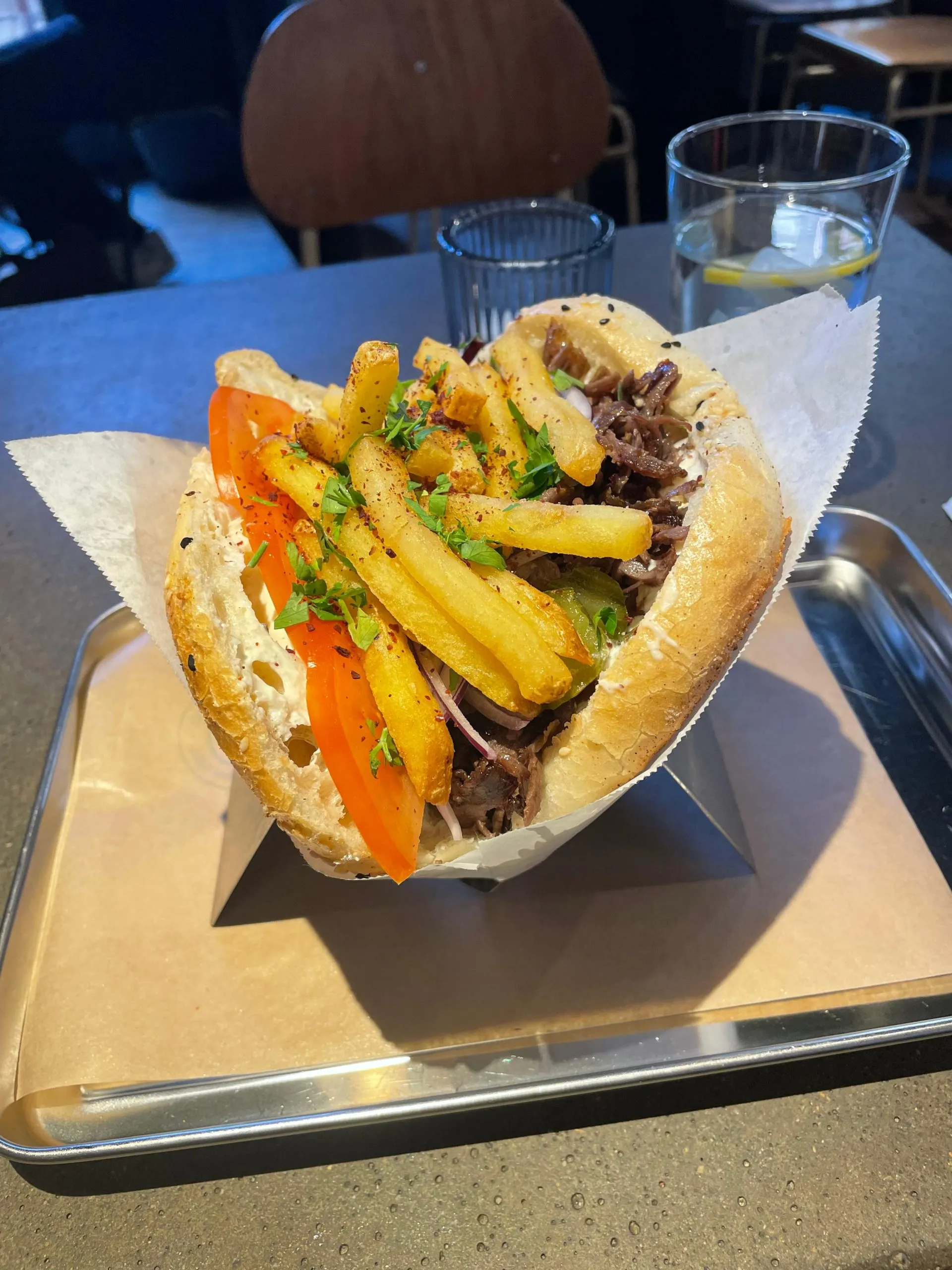 Sandwich with fries and vegetables on table.
