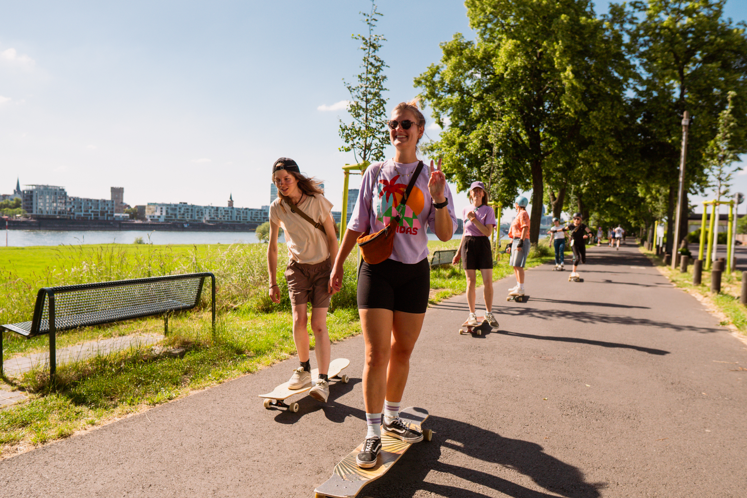 Gruppe von Personen skatet entlang Flussweg.