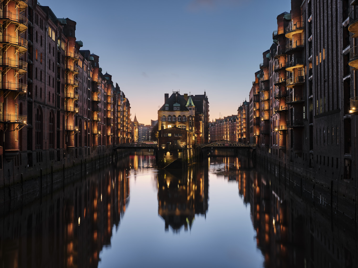 Historisches Lagerhausviertel bei Dämmerung, beleuchtete Gebäude.