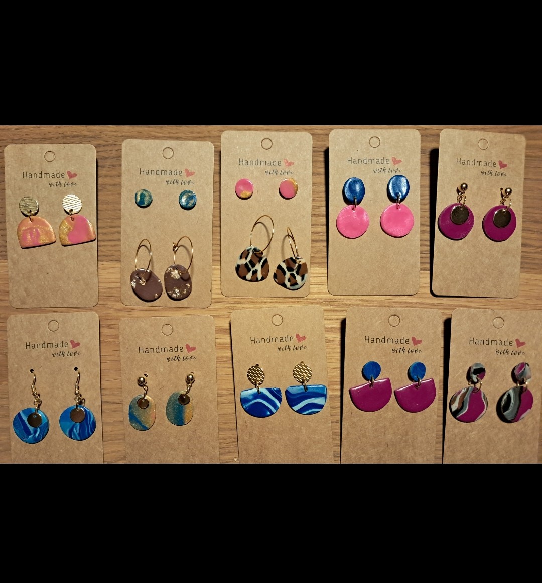 Handmade earrings displayed on cardboard cards.