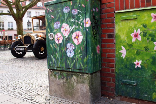 Bunte Blumengrafiken auf einem Elektrizitätskasten in Stadt.