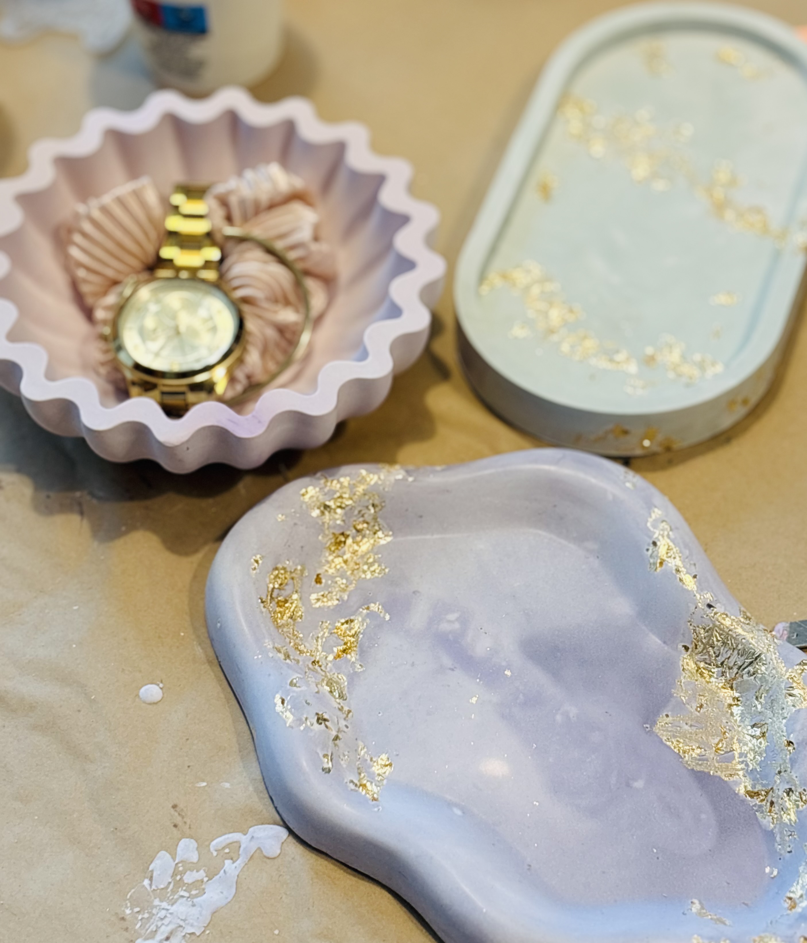 Decorative trays with gold leaf accents on table.