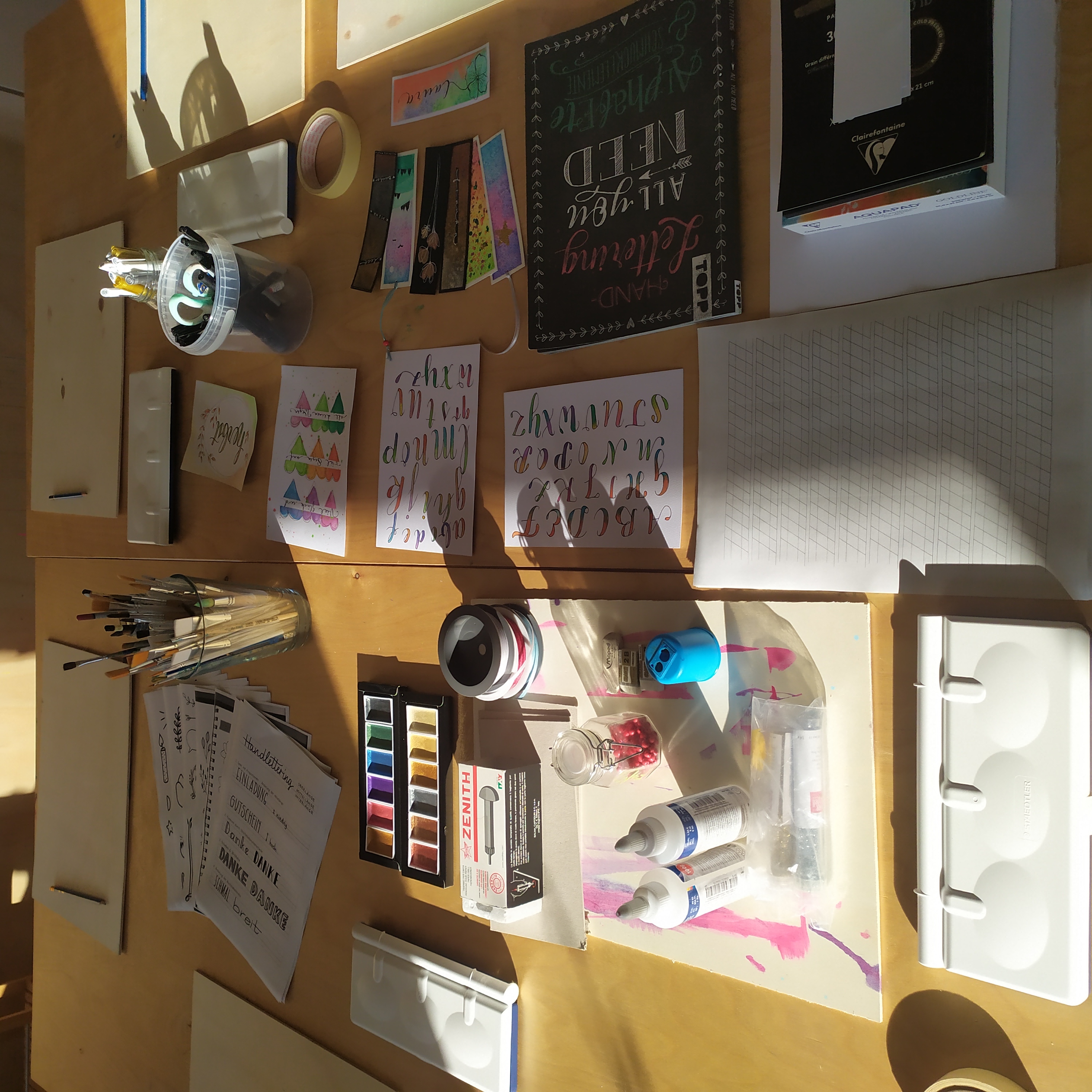 Art supplies arranged on a wooden table.